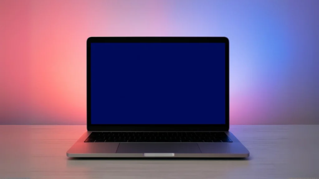 na stole leży otwarty laptop z niebieskim ekranem